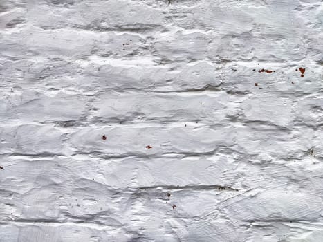 The surface features a textured white finish, emphasizing its imperfect and rustic qualities, reflecting years of exposure and wear.