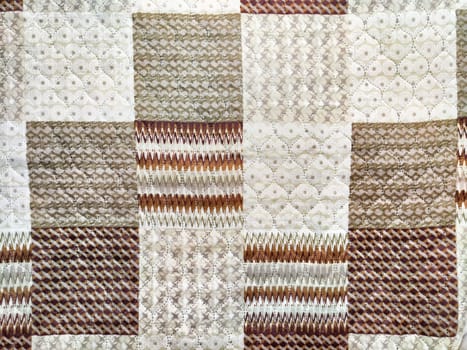 This quilt showcases a blend of intricate textures and patterns, ideal for adding warmth and style to any space.