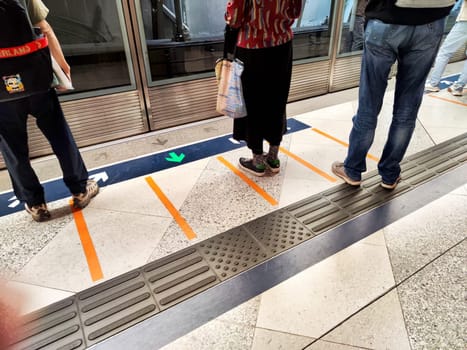 Hong Kong, China - April 09, 2024 - Commuters stand patiently at the subway platform, preparing to board as trains arrive in the bustling city of Hong Kong.