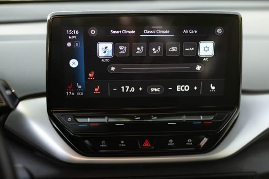 Switching ON heated seats of car by pressing the buttons. Heated seat dashboard in a car. Steering wheel heating button in the car. Electric car control panel with steering wheel and seat heating.
