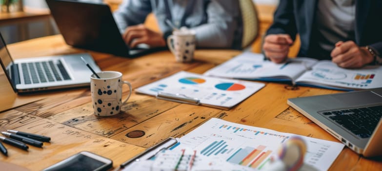 Young professionals collaborate in a dynamic coworking space. laptops, charts, and coffee cups create a productive atmosphere, teamwork in a modern setting. the focus is on exploring financial concepts with visual data.