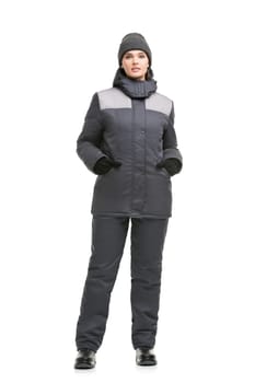 Female in gray working trousers, jacket and knitted cap isolated full-length shot