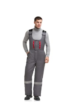 Handsome male in gray work overalls and long sleeve isolated full-length view