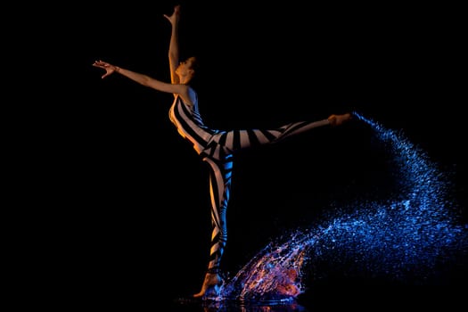 Fitness model dancing profile shot in water drops in the dark room