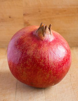 Pomegranate isolated on wooden background
