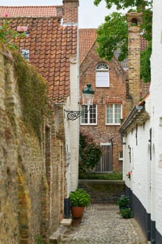 Narrow alley leading to an old brick house in the old town of Bruges in Belgium