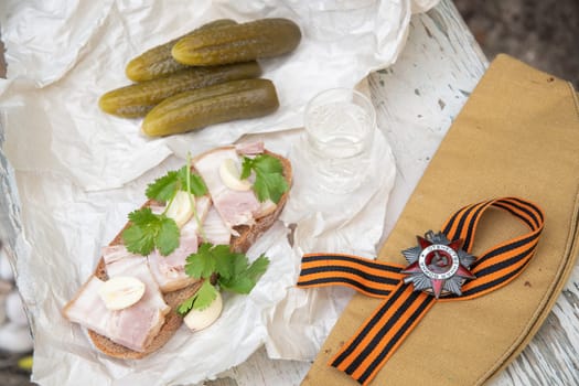 St. George's ribbon, the Order of the Great Patriotic War, May 9, Victory Day, and February 23, Defender of Fatherland Day, still life with a glass of vodka and a snack of lard and pickled cucumber,