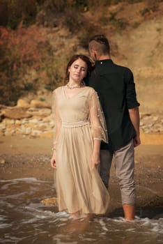 romantic couple in love newlyweds stand hugging on the seashore. girl leaned on her beloved. they stand together near the sea. and dream about their future. the weather is clear