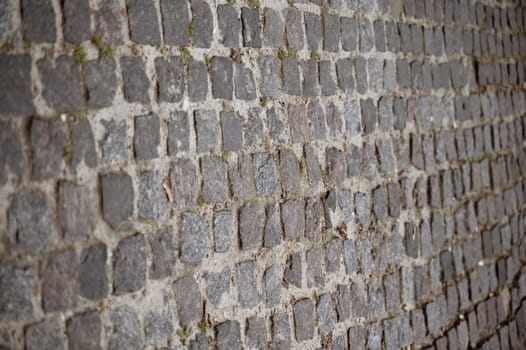 A close up of a brick wall. High quality photo. paving stones gray stone close-up. old vintage road of stones. going from left to right