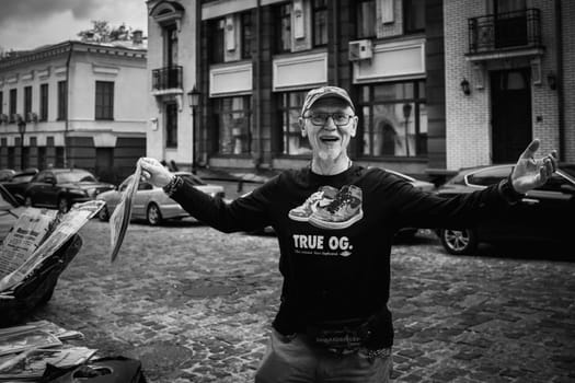 Ukraine, Kiev, 20 September 2023. A stylish man in glasses offers to buy a newspaper. High quality photo
