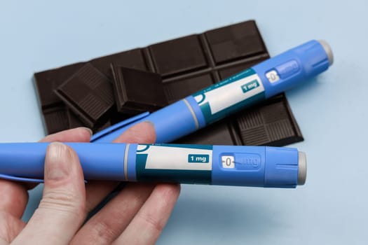 Insulin injection pen and dark chocolate for diabetics and weight loss. High quality photo
