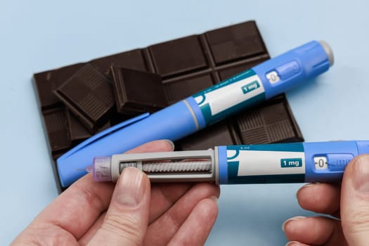 Insulin injection pen and dark chocolate for diabetics and weight loss. High quality photo
