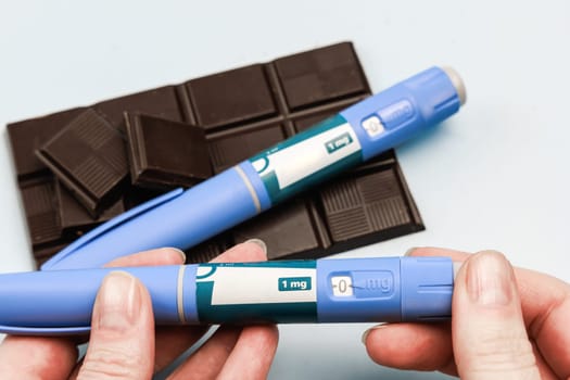 Insulin injection pen and dark chocolate for diabetics and weight loss. High quality photo