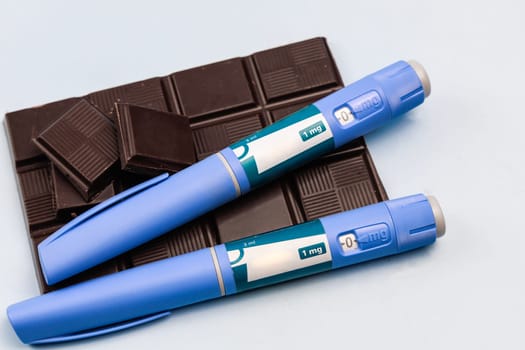 Insulin injection pen and dark chocolate for diabetics and weight loss. High quality photo