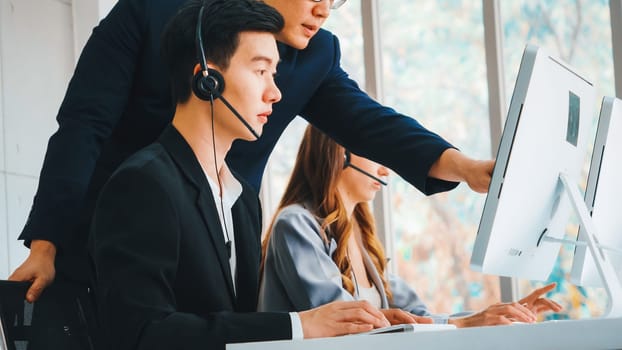 Business people wearing headset working in office to support remote customer or colleague. Call center, telemarketing, customer support agent provide service on telephone video conference call. Jivy