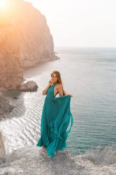 Woman sea trevel green dress. Side view a happy woman with long hair in a long mint dress posing on a beach with calm sea bokeh lights on sunny day. Girl on the nature on blue sky background