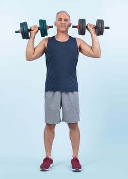 Full body length shot active and sporty senior man lifting dumbbell during weight training workout on isolated background. Healthy active physique and body care lifestyle for pensioner. Clout