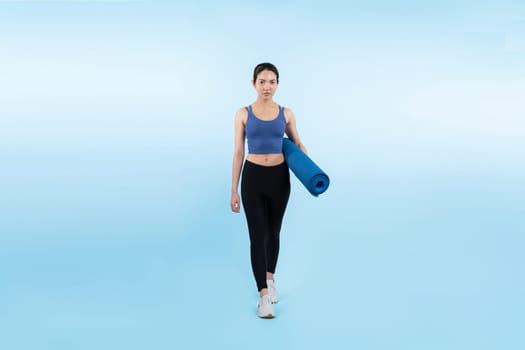 Young attractive asian woman portrait in sportswear with exercising mat. Healthy exercise and workout routine lifestyle concept. Studio shot isolated background. Vigorous