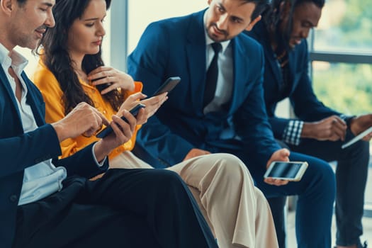 A group of diversity businessman sitting while sharing their data by using smart phone in side view. Smart businesswoman negotiating about finance information with handsome manager. Intellectual.