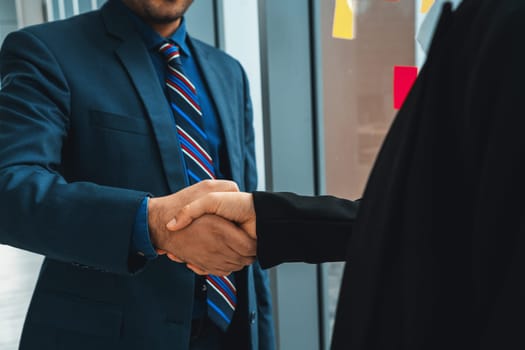 Business people handshake in corporate office showing professional agreement on a financial deal contract. Jivy