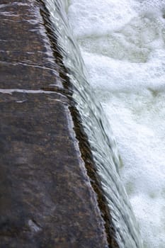 The flow of water in the city waterfall close up