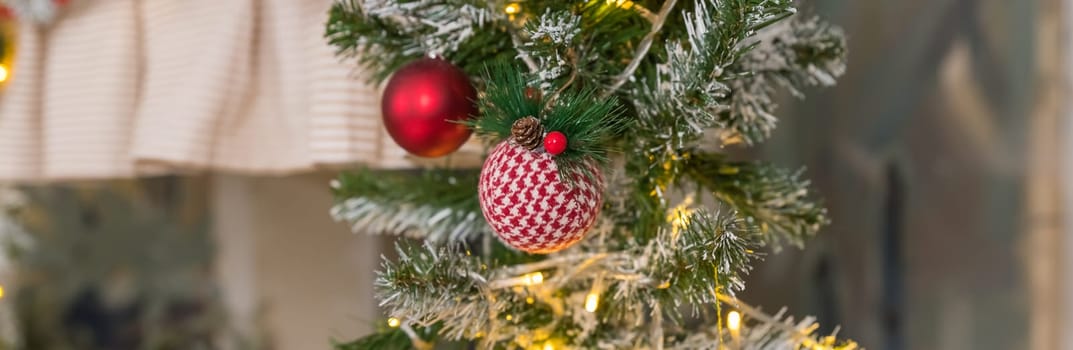 Banner with golden Christmas tree ornament, hanging from fir tree branch with silver tree baubles