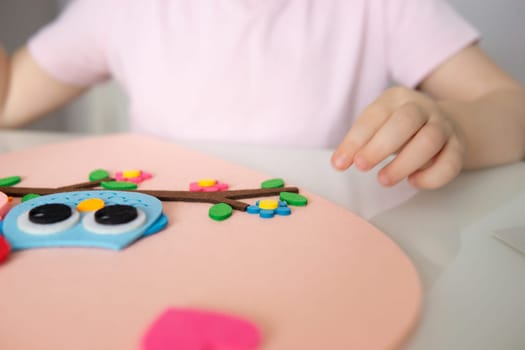 A blogger girl makes a felt craft for Valentine's Day in the shape of a heart. The concept of children's creativity and handmade