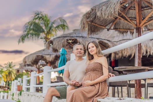 A happy, mature couple over 40, enjoying a leisurely walk in a park, their joy evident as they embrace the journey of pregnancy later in life.