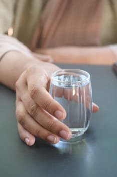 holding a glass of water with copy space .