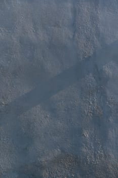 Rays of morning light dance across a textured surface, highlighting intricate patterns and shadows in cool tones.