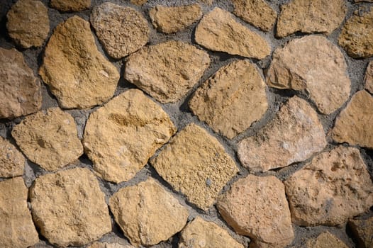 Warm golden stones create a rustic texture against a bright background, highlighting a serene outdoor environment.