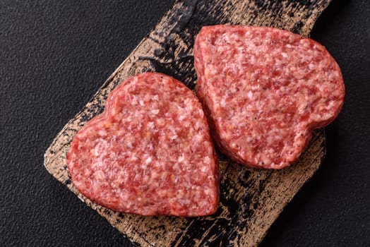 Raw beef or pork burger patty in the shape of a heart with salt, spices and herbs