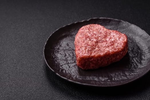 Raw beef or pork burger patty in the shape of a heart with salt, spices and herbs