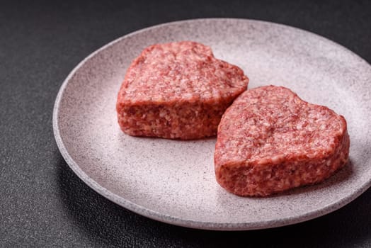 Raw beef or pork burger patty in the shape of a heart with salt, spices and herbs