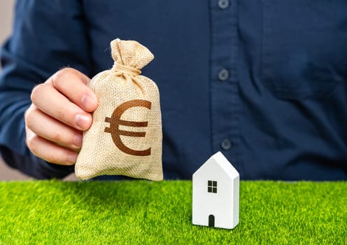 Man presents euro money bag as an offer in exchange for house. Real estate appraisal. Buying a house. Make a deal. Housing prices.