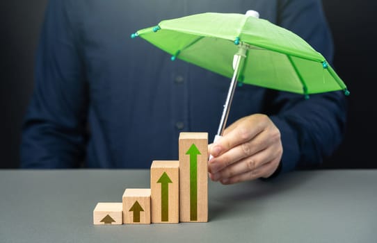 Businessman holding protection umbrella over growth graph. Career advancement. Achieve success and conquer new heights. Insurance umbrella
