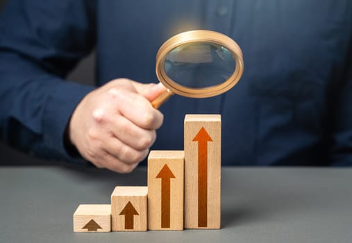 Businessman with magnifying glass study the rapid growth of indicators. Economic and statistical growth points. Optimistic forecast. Entrepreneurship. An alarming trend.