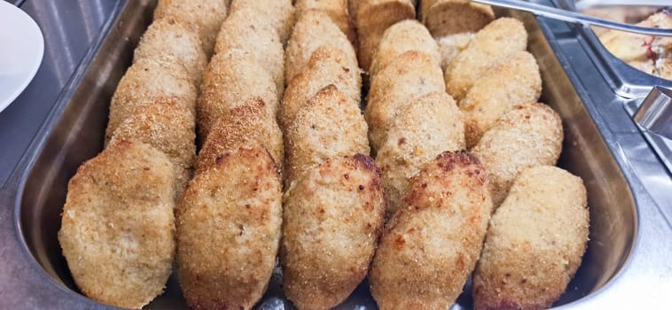 Delicious, golden-brown fried dumplings line a metal tray, showcasing their crispy texture and inviting appearance. These treats are perfect for sharing at any festive gathering.