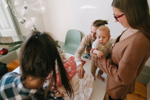 A heartwarming and delightful scene depicting family togetherness and joy during a special giftunwrapping moment
