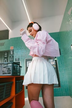 A stylish female figure in a charming pastel look is dancing joyfully with headphones in a vibrant and lively setting