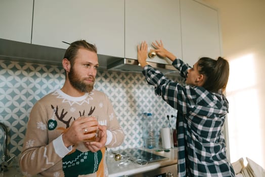 A lovely couple enjoys a warm moment in their stylish and modern kitchen while preparing for the lovely festive season