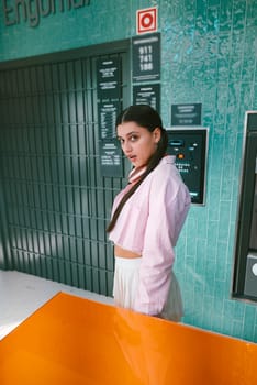 A confident woman poses gracefully in a vibrant urban setting, showcasing the latest contemporary fashion