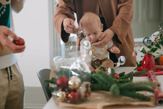 A heartwarming family moment featuring the joy of decorating for Christmas, with a joyful baby included