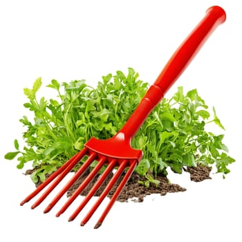 A bright red hand rake is gently placed in a patch of freshly planted green herbs, ready for weeding.