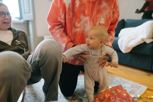 A heartwarming scene of a small baby reaching out for their family members during a joyful festive gathering
