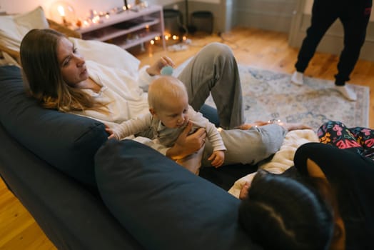 A loving family happily enjoys precious quality time with their adorable baby in a cozy living room setting