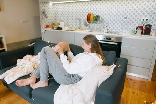 A person is peacefully relaxing on a comfortable couch, cuddling a baby and enjoying the cozy indoor environment