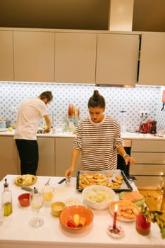 A couple collaborates to prepare a delicious meal in a stylish kitchen, showcasing their teamwork and skills
