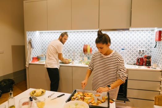 A couple joyfully prepares a meal together in their modern kitchen, showcasing teamwork and enhancing their bond