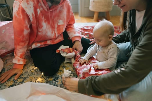 A delightful and joyful moment with a baby engaging in a vibrant family celebration surrounded by colorful gifts